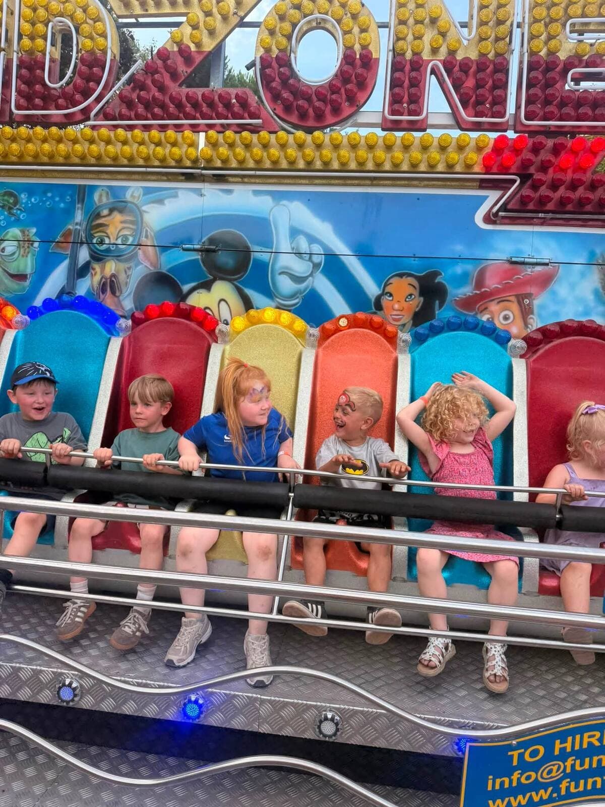 Six children riding the Kidzone fairground ride at the WN7 FEST Garden Party in Glazebury