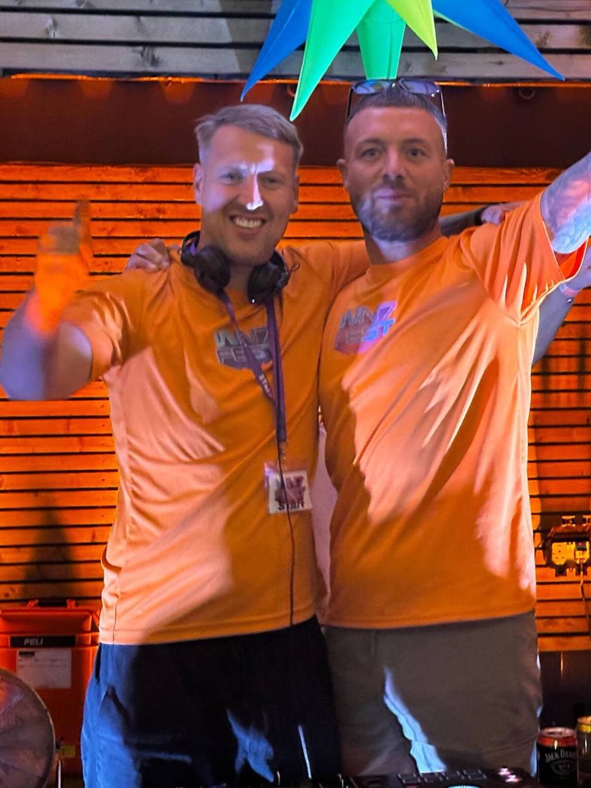 Two WN7 FEST crew members celebrating behind the decks at the Garden Party