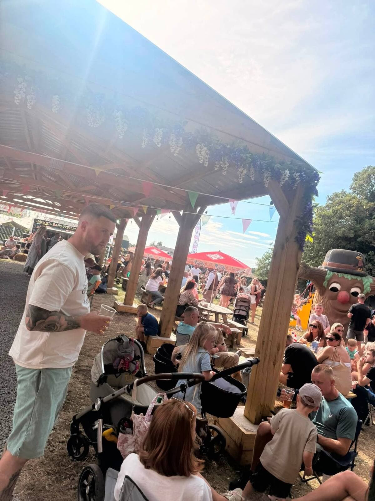 Prams and bunting under the flower-draped pergola at the WN7 FEST Garden Party