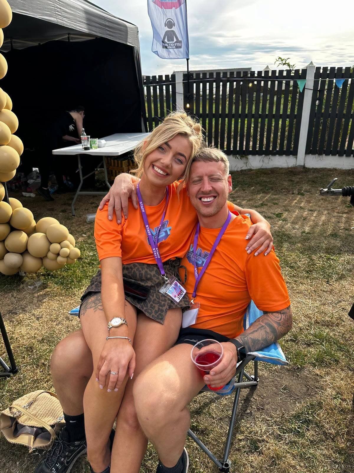 Two WN7 FEST crew members in orange shirts at the Garden Party